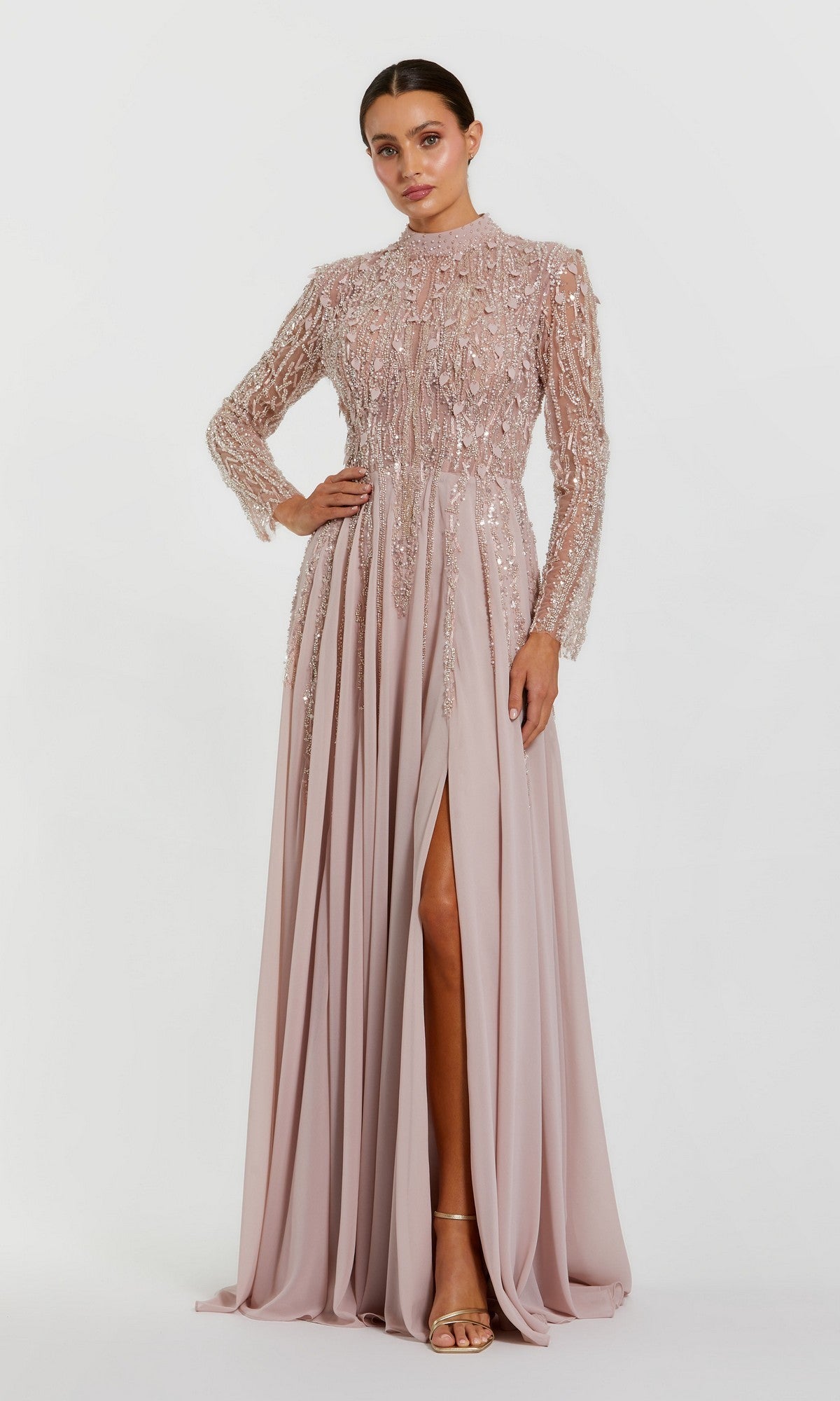 A woman wearing the Mac Duggal 37037 long formal dress in dusty rose, featuring sequin details and a front slit, stands against a plain white background.